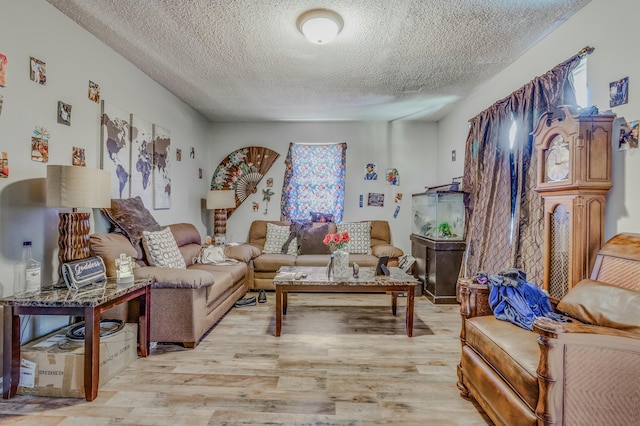 living room with a healthy amount of sunlight, light hardwood / wood-style floors, and a textured ceiling