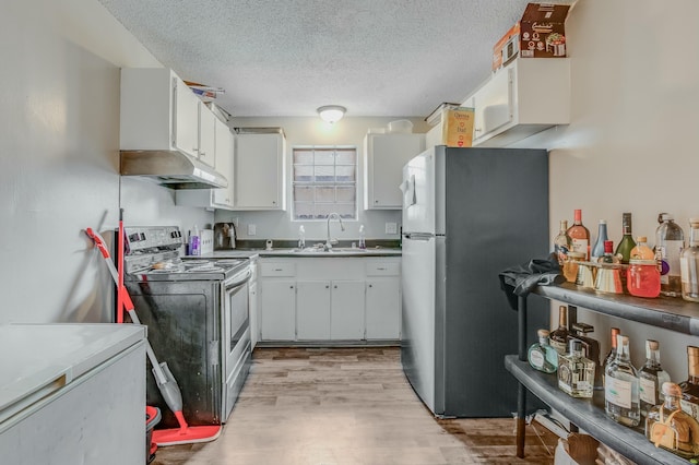 kitchen featuring sink, white cabinetry, a textured ceiling, appliances with stainless steel finishes, and light hardwood / wood-style floors