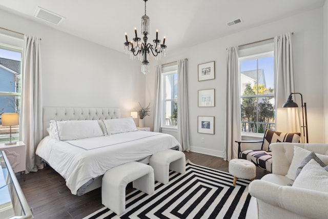 bedroom featuring multiple windows, a chandelier, and dark hardwood / wood-style flooring