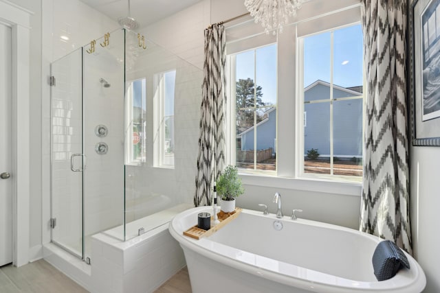 bathroom with shower with separate bathtub and a healthy amount of sunlight