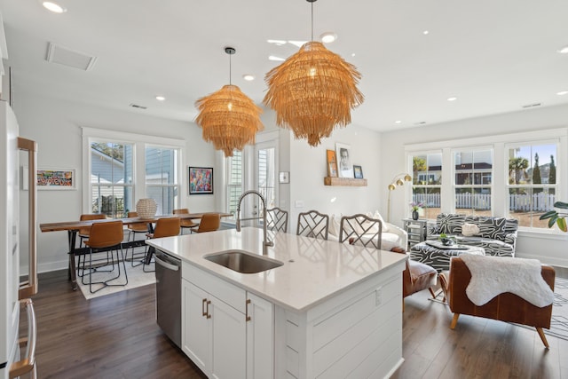 kitchen featuring dishwasher, sink, white cabinets, dark hardwood / wood-style flooring, and hanging light fixtures