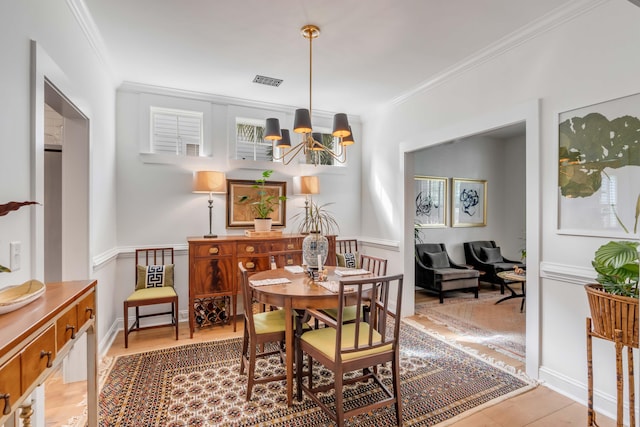 dining space featuring crown molding and an inviting chandelier