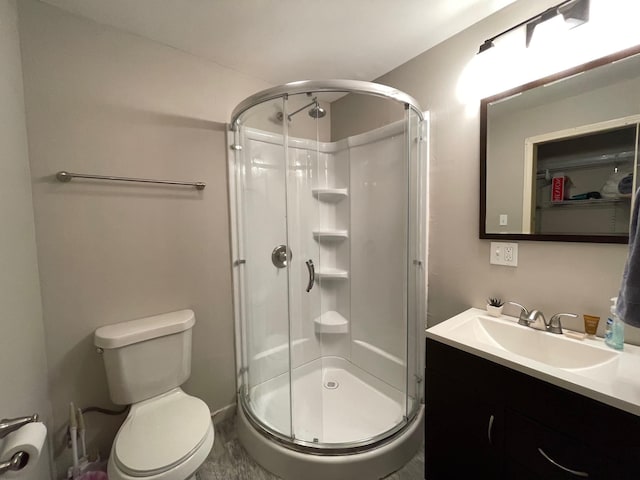 bathroom featuring vanity, toilet, and an enclosed shower