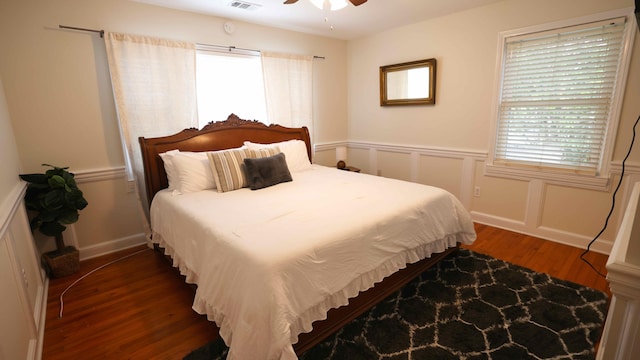 bedroom with dark hardwood / wood-style flooring and ceiling fan