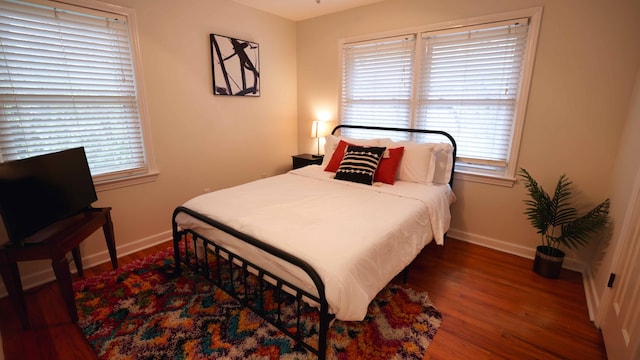 bedroom with dark hardwood / wood-style floors