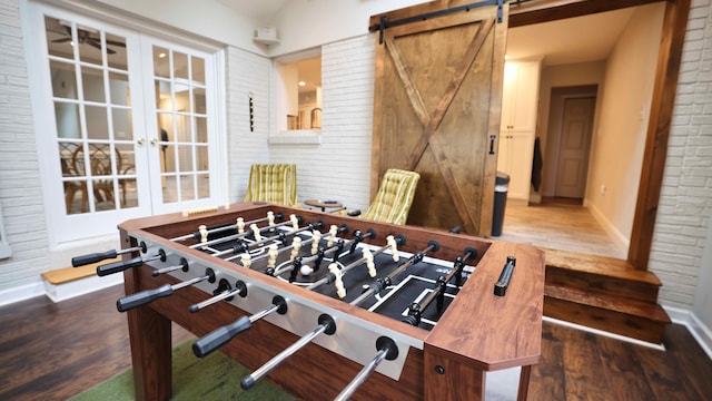 playroom featuring french doors, a barn door, and hardwood / wood-style floors