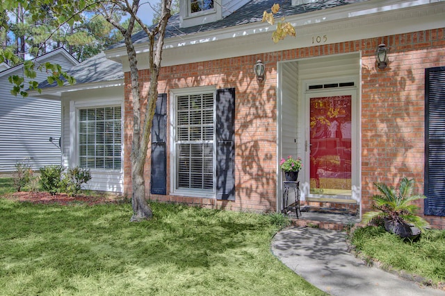 property entrance featuring a lawn