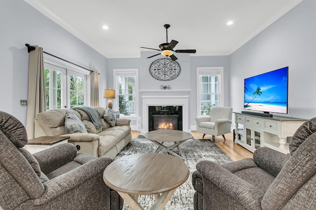 living room featuring ceiling fan, wood-type flooring, and crown molding