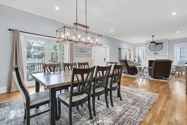 dining area with ceiling fan with notable chandelier, light hardwood / wood-style floors, and ornamental molding