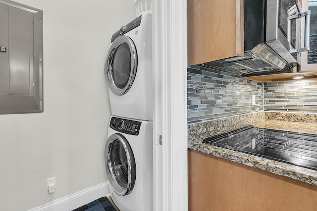 laundry area featuring stacked washing maching and dryer and electric panel