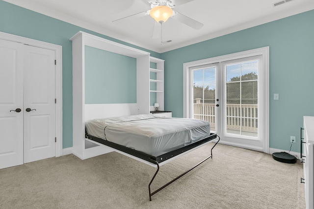 bedroom with access to exterior, ceiling fan, a closet, and light colored carpet