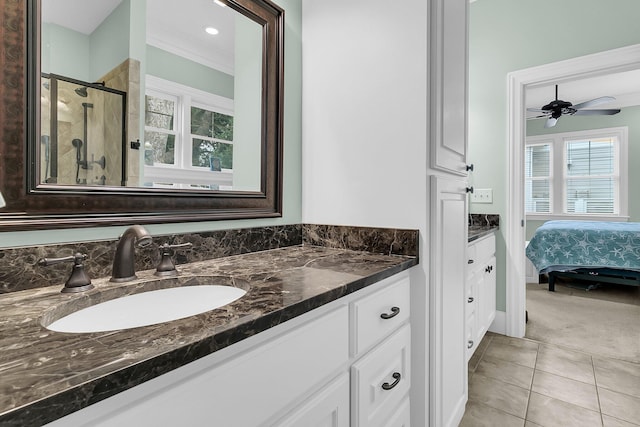 bathroom featuring walk in shower, ornamental molding, vanity, ceiling fan, and tile patterned flooring