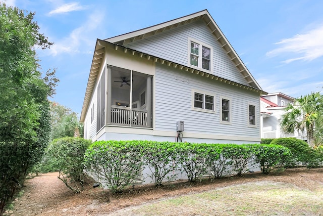 view of home's exterior featuring a sunroom and ceiling fan