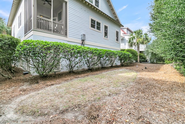 view of side of property featuring ceiling fan and a sunroom