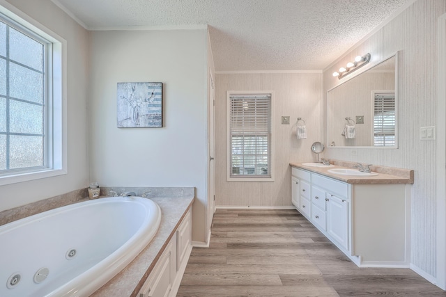 bathroom featuring a textured ceiling, a healthy amount of sunlight, and a tub