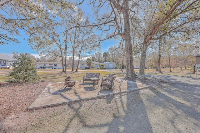 view of patio / terrace featuring an outdoor fire pit and a storage unit