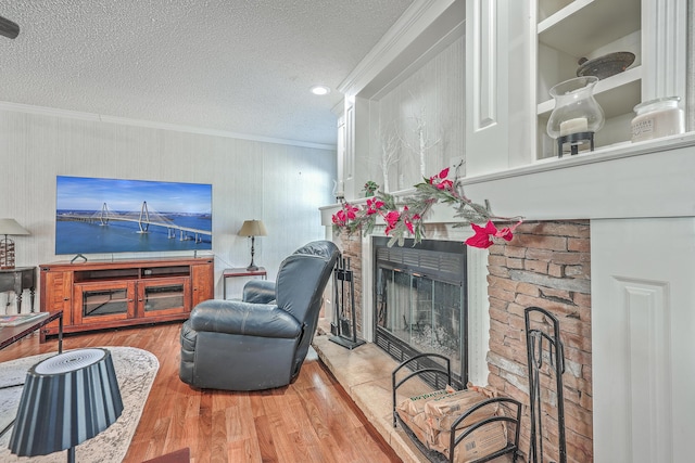 living room featuring a fireplace, crown molding, a textured ceiling, and hardwood / wood-style flooring