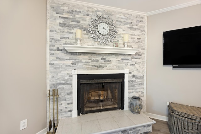 room details featuring a large fireplace, baseboards, and ornamental molding