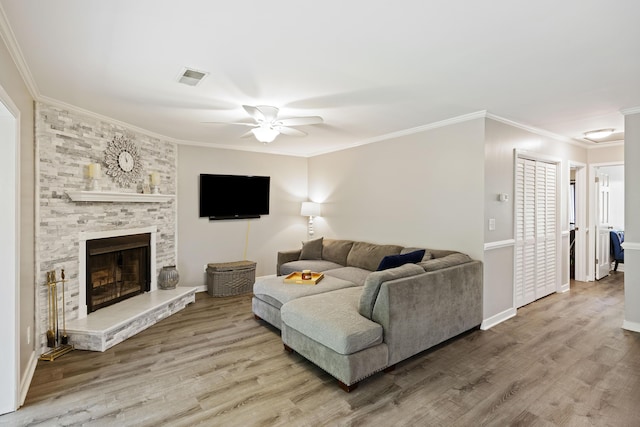 living area featuring visible vents, ornamental molding, and wood finished floors