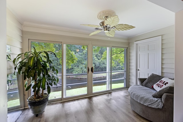 interior space with a ceiling fan and a water view