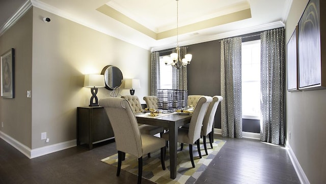 dining room with dark hardwood / wood-style floors, ornamental molding, a raised ceiling, and a notable chandelier