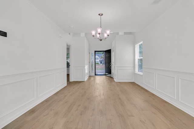 4823 Shady Tree Ln, Summerville, SC 29485 - unfurnished dining area with a chandelier, a decorative wall, light wood-style floors, and a wainscoted wall