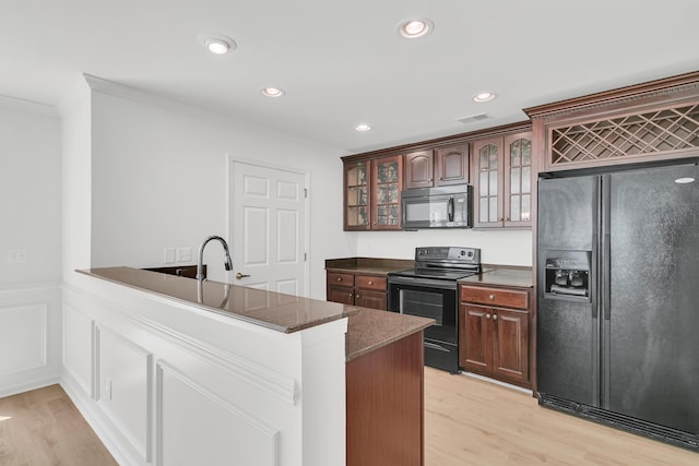 4823 Shady Tree Ln, Summerville, SC 29485 - kitchen with black appliances, crown molding, a peninsula, light wood-type flooring, and glass insert cabinets