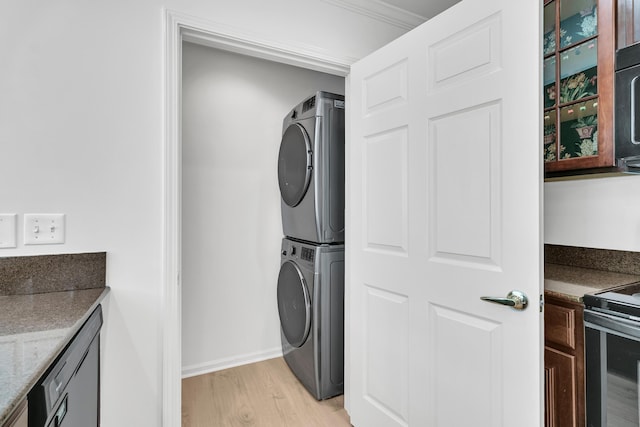4823 Shady Tree Ln, Summerville, SC 29485 - laundry room featuring stacked washer and clothes dryer, light wood-type flooring, and baseboards
