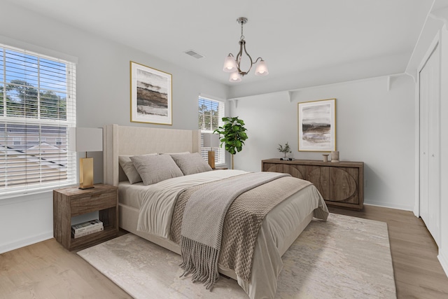4823 Shady Tree Ln, Summerville, SC 29485 - bedroom featuring light wood-style flooring, baseboards, and a chandelier