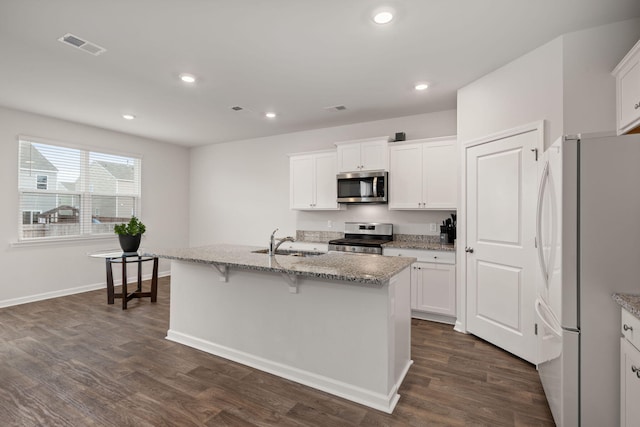 kitchen featuring white cabinetry, sink, light stone counters, a center island with sink, and appliances with stainless steel finishes