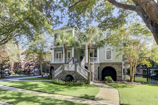 view of front of property featuring a front lawn, french doors, and covered porch