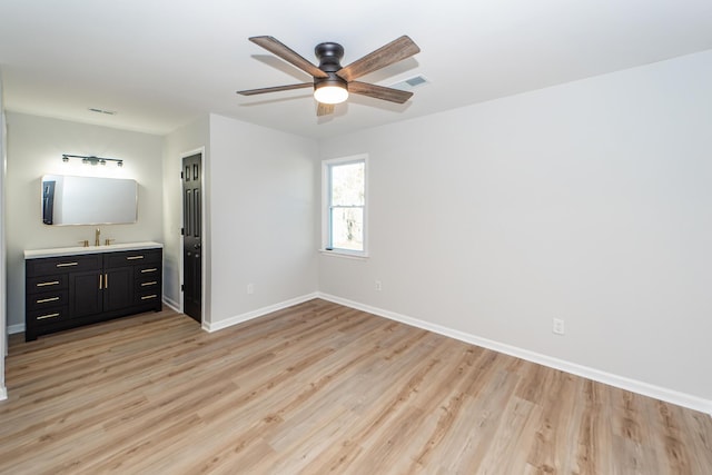 unfurnished bedroom featuring ensuite bathroom, ceiling fan, and light hardwood / wood-style floors