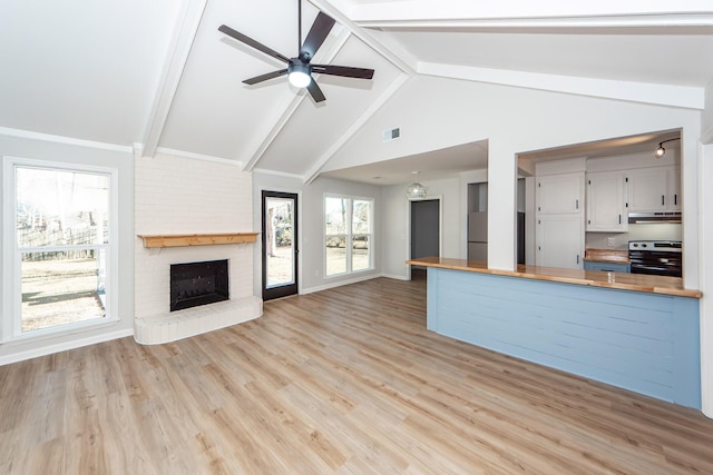 kitchen with kitchen peninsula, wood counters, stainless steel electric stove, lofted ceiling with beams, and a fireplace