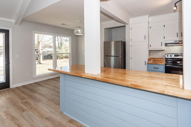 kitchen with appliances with stainless steel finishes, pendant lighting, light hardwood / wood-style flooring, white cabinets, and butcher block countertops