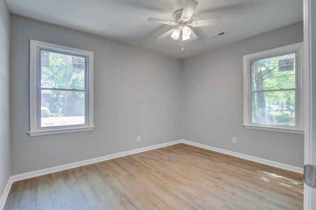 unfurnished room with a healthy amount of sunlight, ceiling fan, and light wood-type flooring