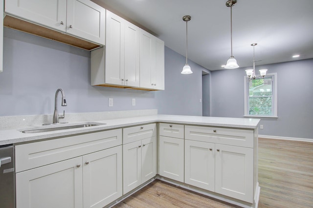 kitchen with light hardwood / wood-style flooring, decorative light fixtures, white cabinets, and sink