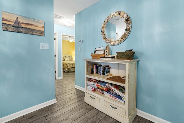 hall with hardwood / wood-style flooring and a textured ceiling