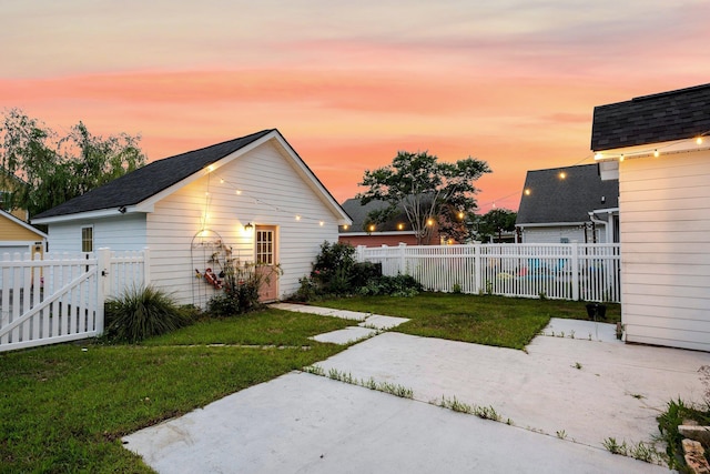 yard at dusk with a patio area and a gate