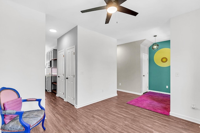 unfurnished room featuring ceiling fan, wood finished floors, and baseboards