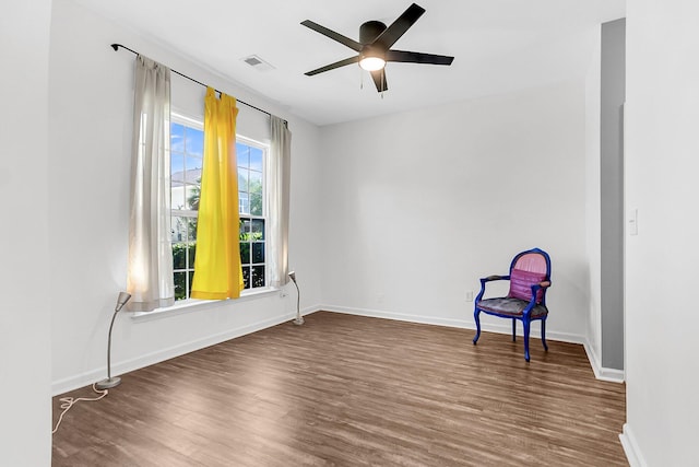 unfurnished room with wood finished floors, baseboards, and a ceiling fan