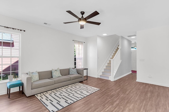 living area featuring wood finished floors, baseboards, ceiling fan, stairs, and recessed lighting