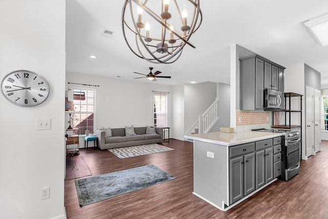 kitchen featuring stainless steel microwave, range with electric cooktop, gray cabinetry, dark wood-style floors, and decorative backsplash