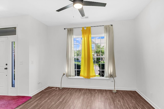 spare room featuring wood finished floors, baseboards, and ceiling fan