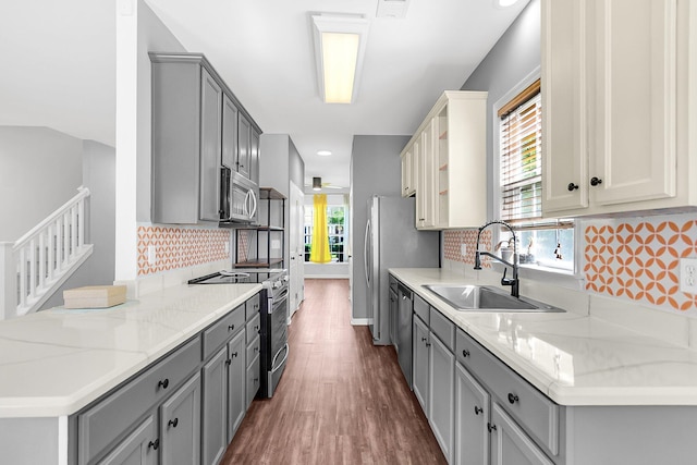 kitchen with stainless steel appliances, gray cabinetry, a sink, plenty of natural light, and recessed lighting