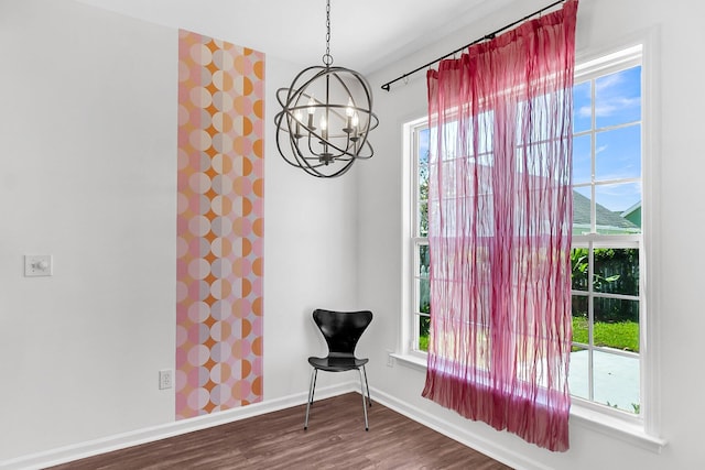 living area with baseboards, a chandelier, wood finished floors, and wallpapered walls