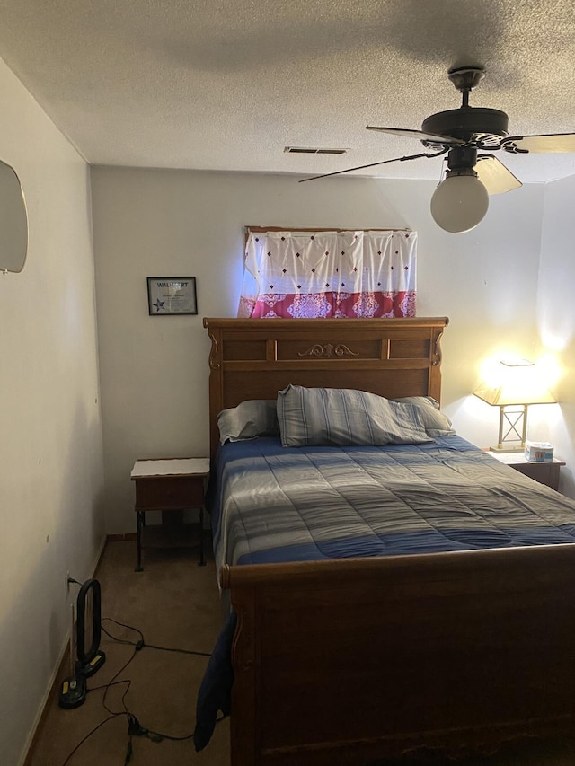 bedroom featuring a textured ceiling, carpet floors, and ceiling fan