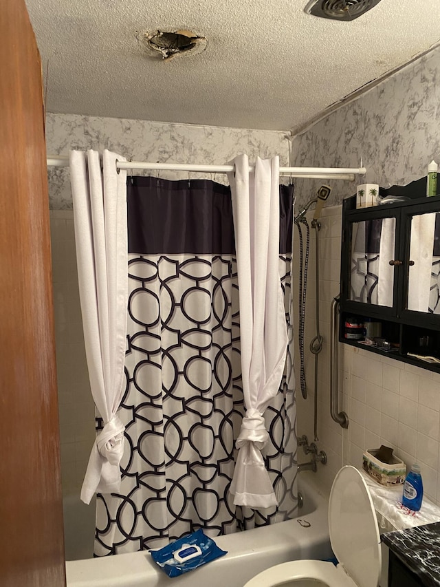 bathroom with shower / bathtub combination with curtain, a textured ceiling, and toilet