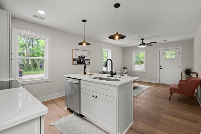 kitchen featuring dishwasher, a sink, white cabinetry, baseboards, and decorative light fixtures