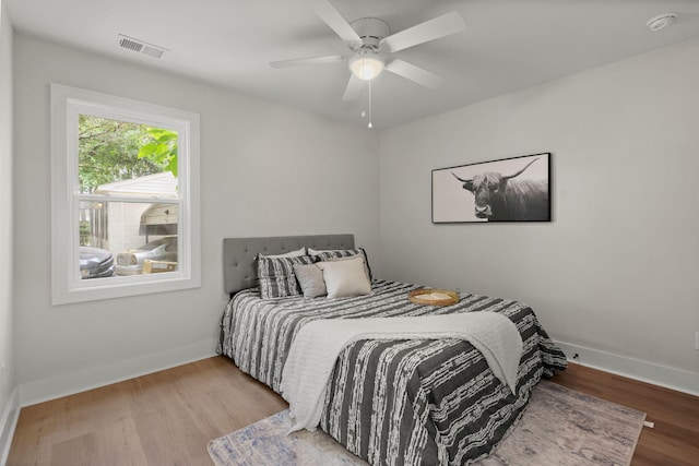 bedroom featuring wood finished floors, baseboards, and ceiling fan