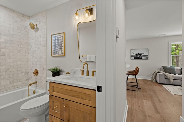 bathroom with wood finished floors, toilet, vanity, and shower / bath combination